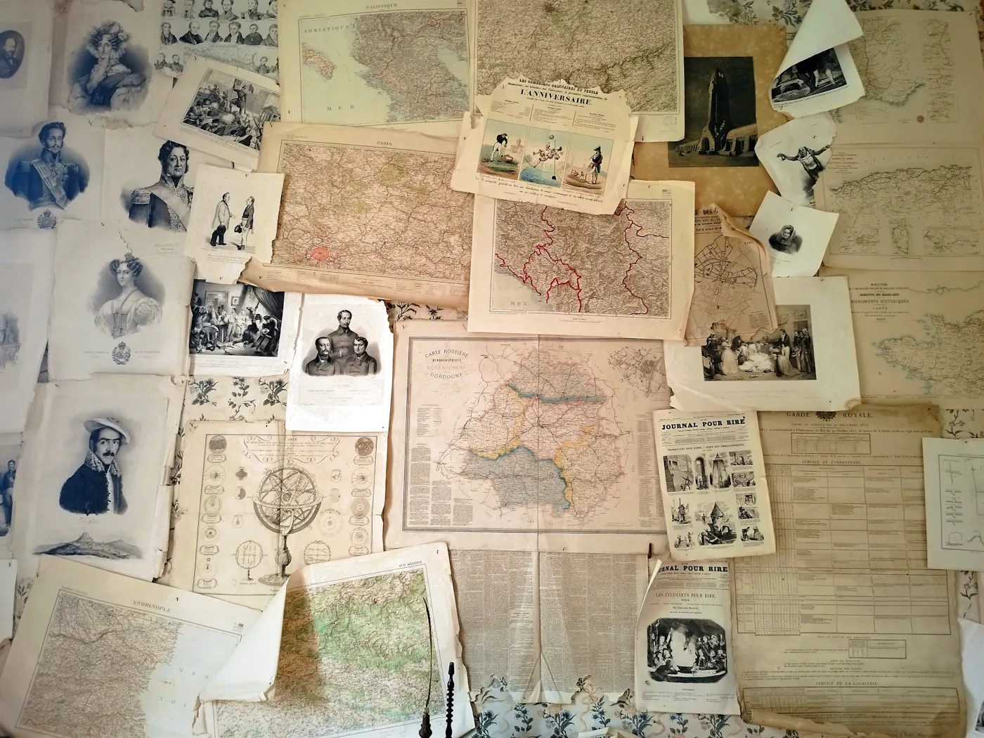 Several old printed maps spread across a table